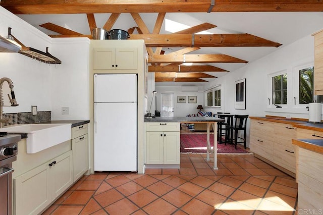 934 Arden Dr, Encinitas, CA 92024 - kitchen featuring freestanding refrigerator, a wall mounted air conditioner, dark countertops, tasteful backsplash, and light tile patterned floors