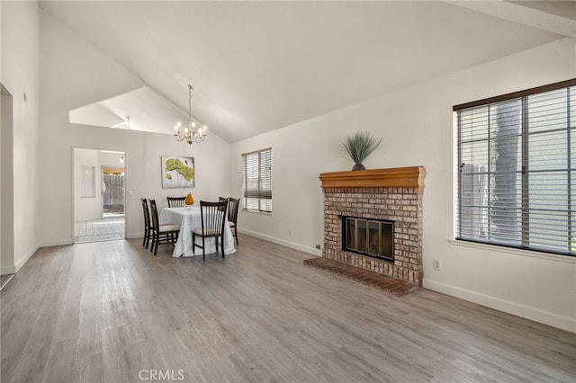 7353 Cascade Ct, Rancho Cucamonga, CA 91730 - dining space featuring wood finished floors, a chandelier, a brick fireplace, and high vaulted ceiling