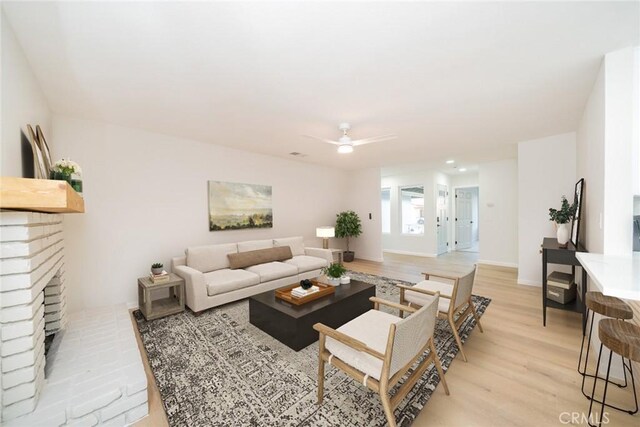 5955 Scheelite St, Jurupa Valley, CA 92509 - living area with light wood-style floors, a brick fireplace, and ceiling fan