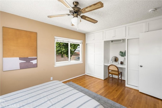 15027 Barnwall St, La Mirada, CA 90638 - bedroom featuring wood finished floors, a textured ceiling, freestanding refrigerator, built in desk, and a ceiling fan
