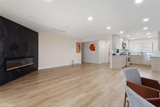 10535 Reseda Blvd, Porter Ranch, CA 91326 - living room featuring light wood-style floors, recessed lighting, and a large fireplace