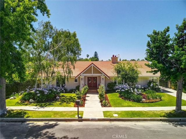 4843 Texhoma Ave, Encino, CA 91316 - view of front of home featuring a tile roof, a chimney, a front yard, and french doors