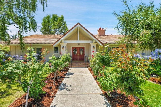4843 Texhoma Ave, Encino, CA 91316 - view of front of property featuring a tile roof, french doors, a chimney, and board and batten siding