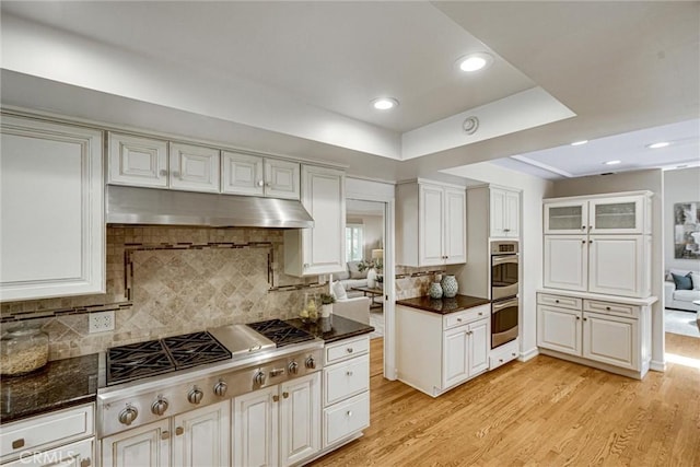 4843 Texhoma Ave, Encino, CA 91316 - kitchen featuring under cabinet range hood, stainless steel appliances, light wood-style flooring, decorative backsplash, and white cabinetry