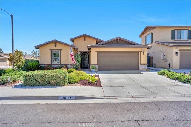 29183 Jacaranda, Lake Elsinore, CA 92530 - view of front facade featuring stucco siding, an attached garage, concrete driveway, and stone siding