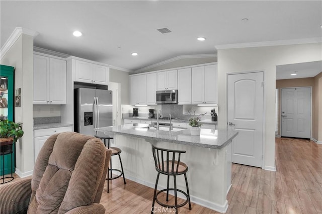 29183 Jacaranda, Lake Elsinore, CA 92530 - kitchen with appliances with stainless steel finishes, crown molding, vaulted ceiling, white cabinetry, and a kitchen breakfast bar