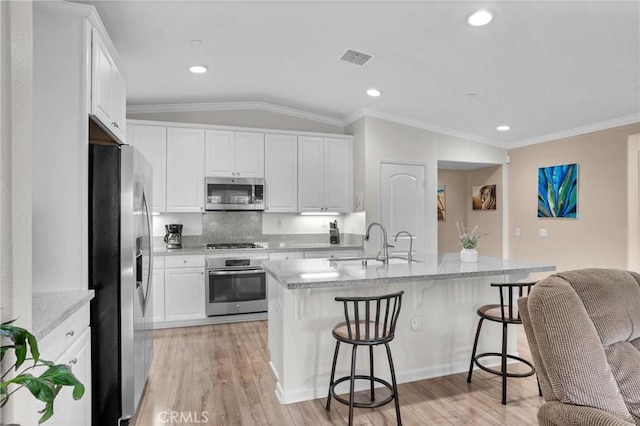 29183 Jacaranda, Lake Elsinore, CA 92530 - kitchen featuring appliances with stainless steel finishes, white cabinets, a breakfast bar area, decorative backsplash, and crown molding