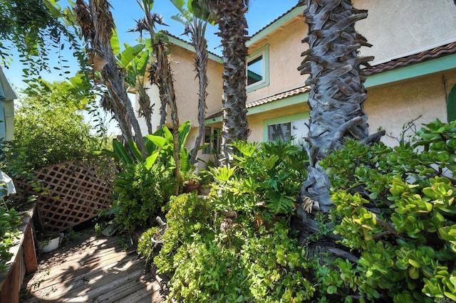 250 65th St, San Diego, CA 92114 - view of side of home featuring stucco siding, a tiled roof, and a deck
