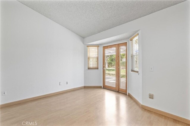 2065 N Shorewood Ave, Upland, CA 91784 - empty room with light wood-style floors, a textured ceiling, and vaulted ceiling