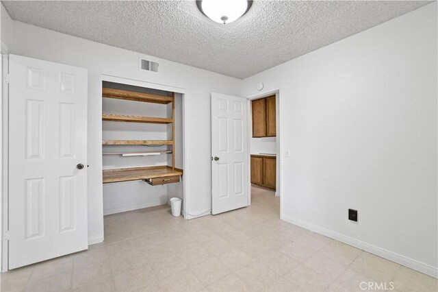 2065 N Shorewood Ave, Upland, CA 91784 - unfurnished bedroom featuring a textured ceiling, a closet, built in study area, and light floors