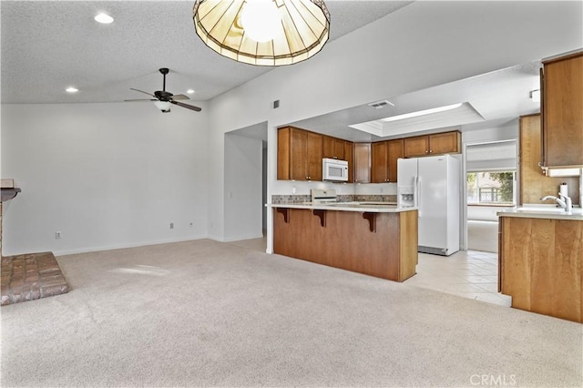 2065 N Shorewood Ave, Upland, CA 91784 - kitchen featuring white appliances, open floor plan, light carpet, a breakfast bar, and recessed lighting