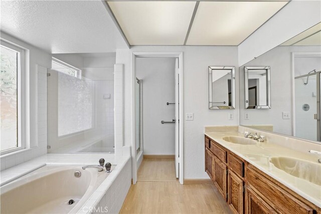 2065 N Shorewood Ave, Upland, CA 91784 - bathroom with a garden tub, a stall shower, double vanity, and wood finished floors