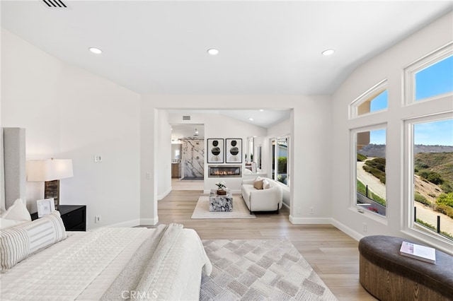 7 Sierra Vis, Laguna Niguel, CA 92677 - bedroom featuring a glass covered fireplace, light wood finished floors, recessed lighting, and vaulted ceiling