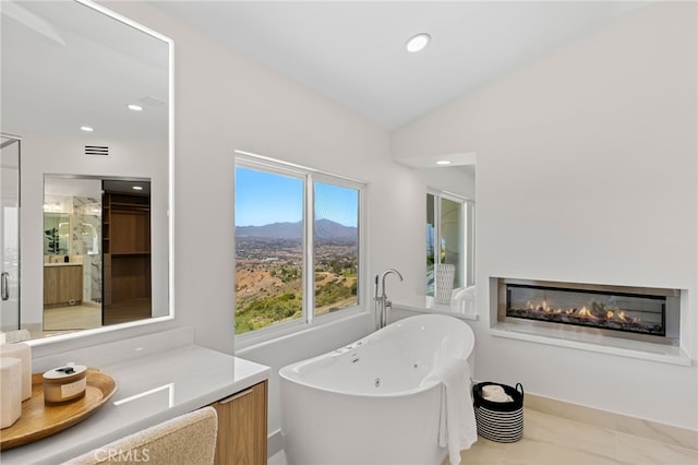 7 Sierra Vis, Laguna Niguel, CA 92677 - full bathroom with a freestanding tub, a glass covered fireplace, vanity, recessed lighting, and lofted ceiling