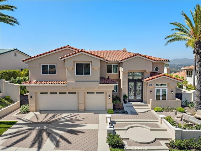 7 Sierra Vis, Laguna Niguel, CA 92677 - mediterranean / spanish-style house featuring french doors, stucco siding, a tiled roof, a garage, and driveway