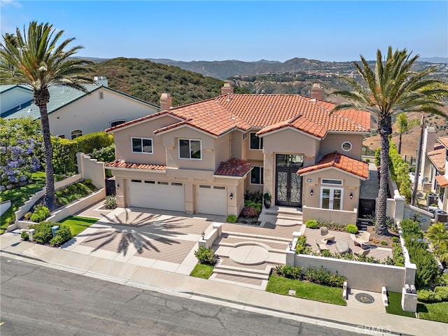 7 Sierra Vis, Laguna Niguel, CA 92677 - mediterranean / spanish-style house featuring french doors, a tile roof, a garage, stucco siding, and driveway