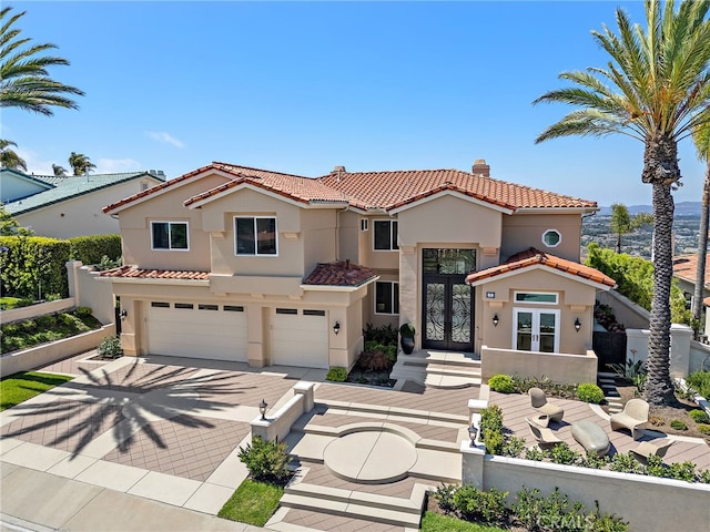 7 Sierra Vis, Laguna Niguel, CA 92677 - mediterranean / spanish-style house with french doors, a tiled roof, stucco siding, a garage, and decorative driveway