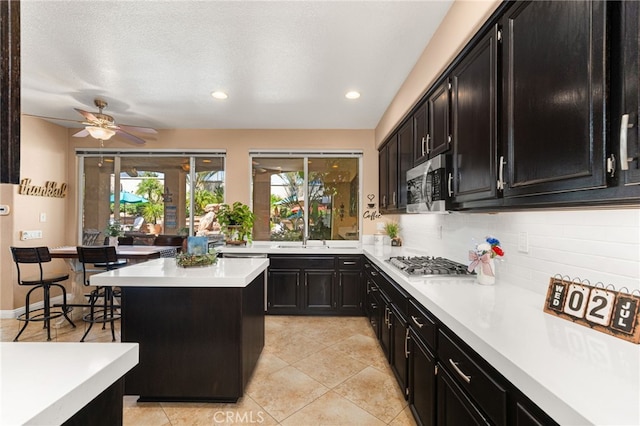 5601 Crestline Pl, Rancho Cucamonga, CA 91739 - kitchen featuring dark cabinets, appliances with stainless steel finishes, light countertops, decorative backsplash, and recessed lighting