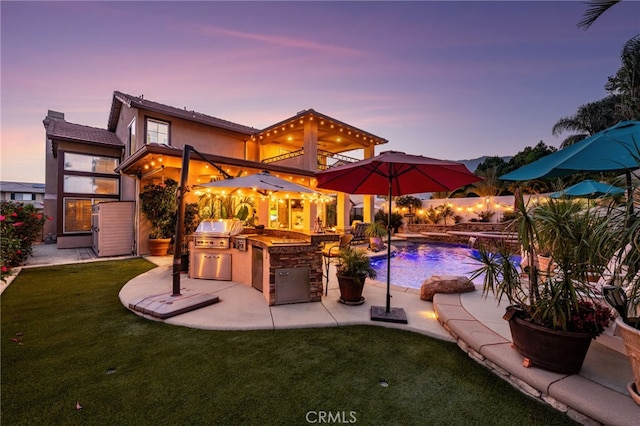 5601 Crestline Pl, Rancho Cucamonga, CA 91739 - view of pool featuring an outdoor kitchen, a patio, a lawn, exterior bar, and a pool with connected hot tub