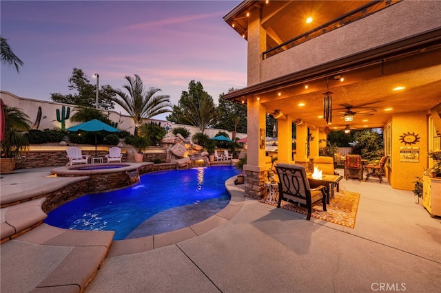 5601 Crestline Pl, Rancho Cucamonga, CA 91739 - pool at dusk with an outdoor fire pit, a patio, ceiling fan, a pool with connected hot tub, and a fenced backyard