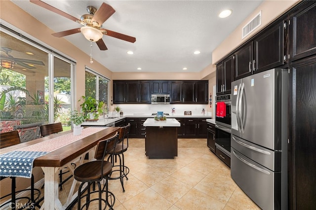 5601 Crestline Pl, Rancho Cucamonga, CA 91739 - kitchen featuring stainless steel appliances, a ceiling fan, light countertops, a kitchen island, and light tile patterned floors