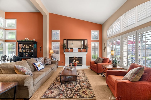 5601 Crestline Pl, Rancho Cucamonga, CA 91739 - living room with light colored carpet, healthy amount of natural light, high vaulted ceiling, and a lit fireplace