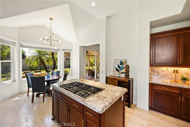 5914 Johnston Pl, Rancho Cucamonga, CA 91739 - kitchen featuring stainless steel gas cooktop, light stone counters, a chandelier, lofted ceiling, and decorative backsplash
