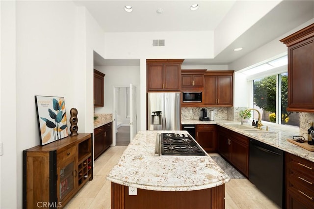 5914 Johnston Pl, Rancho Cucamonga, CA 91739 - kitchen with black appliances, a center island, backsplash, recessed lighting, and light stone countertops