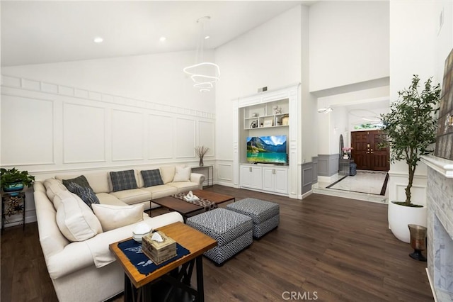 5914 Johnston Pl, Rancho Cucamonga, CA 91739 - living area featuring a decorative wall, high vaulted ceiling, dark wood-style flooring, and a wainscoted wall