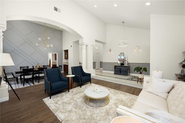 5914 Johnston Pl, Rancho Cucamonga, CA 91739 - living area with a decorative wall, a chandelier, arched walkways, high vaulted ceiling, and wood finished floors