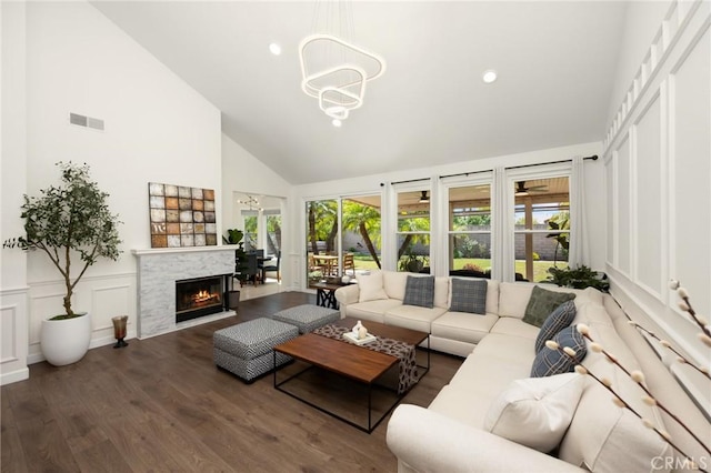 5914 Johnston Pl, Rancho Cucamonga, CA 91739 - living room featuring high vaulted ceiling, wood finished floors, a fireplace, a chandelier, and a decorative wall