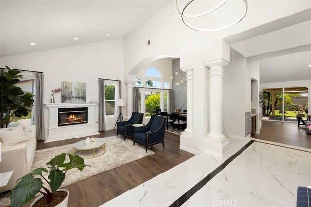 5914 Johnston Pl, Rancho Cucamonga, CA 91739 - living area with decorative columns, plenty of natural light, a towering ceiling, a glass covered fireplace, and recessed lighting