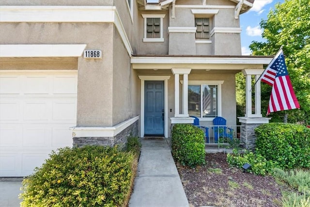11868 Bunker Hill Dr, Rancho Cucamonga, CA 91730 - doorway to property with stucco siding, covered porch, stone siding, and an attached garage