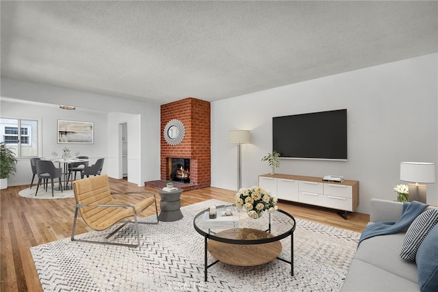 1014 W 185th St, Gardena, CA 90248 - living area with a textured ceiling, light wood finished floors, and a brick fireplace
