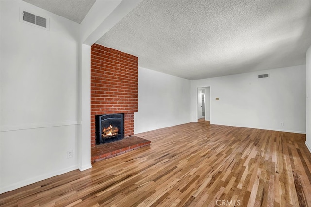 1014 W 185th St, Gardena, CA 90248 - unfurnished living room featuring a textured ceiling, wood finished floors, and a fireplace