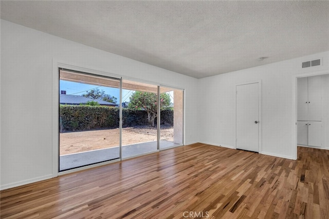 1014 W 185th St, Gardena, CA 90248 - unfurnished bedroom featuring access to outside, wood finished floors, and a textured ceiling