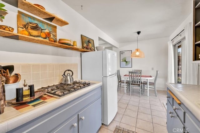 7638 Dumosa Ave, Yucca Valley, CA 92284 - kitchen with open shelves, tile countertops, stainless steel gas cooktop, and gray cabinetry