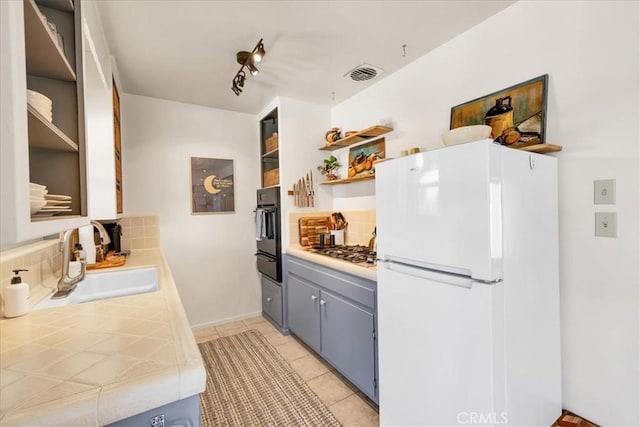 7638 Dumosa Ave, Yucca Valley, CA 92284 - kitchen with freestanding refrigerator, open shelves, backsplash, oven, and a warming drawer