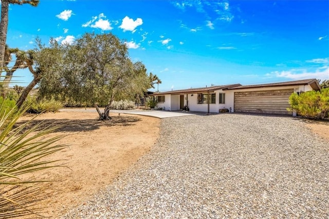 7638 Dumosa Ave, Yucca Valley, CA 92284 - view of front facade featuring an attached garage, driveway, and stucco siding