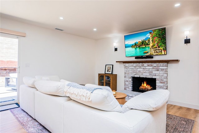 9140 Garden St, Rancho Cucamonga, CA 91701 - living area featuring wood finished floors, a brick fireplace, healthy amount of natural light, and recessed lighting
