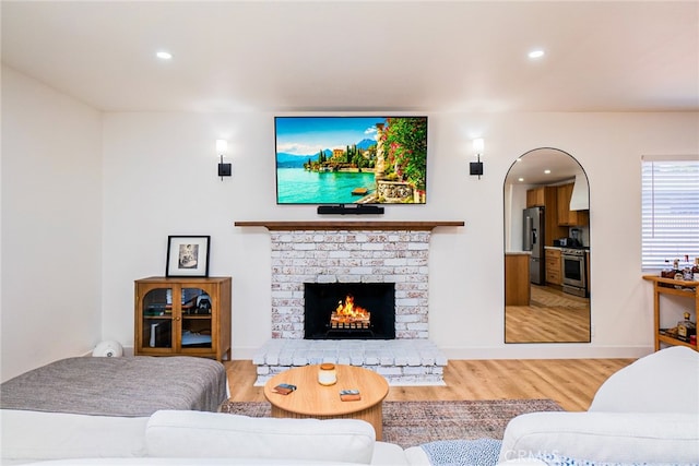 9140 Garden St, Rancho Cucamonga, CA 91701 - living area featuring light wood-type flooring, arched walkways, recessed lighting, and a fireplace