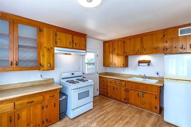 14836 Rayfield Dr, La Mirada, CA 90638 - kitchen with white appliances, under cabinet range hood, brown cabinets, and light countertops