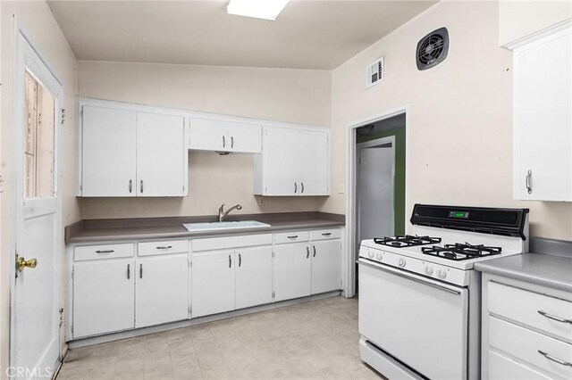 2344 Porter Way, Chico, CA 95926 - kitchen featuring white gas range oven, white cabinetry, dark countertops, and lofted ceiling