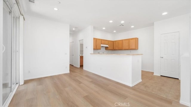 10375 Church St Unit 74, Rancho Cucamonga, CA 91730 - kitchen with under cabinet range hood, recessed lighting, light countertops, light wood finished floors, and a peninsula