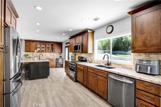 17321 Sunset View Dr, Riverside, CA 92504 - kitchen featuring appliances with stainless steel finishes, light stone counters, tasteful backsplash, light wood-type flooring, and recessed lighting