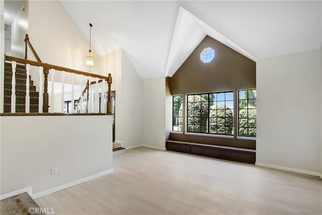 17321 Sunset View Dr, Riverside, CA 92504 - unfurnished living room featuring wood finished floors, stairway, and high vaulted ceiling