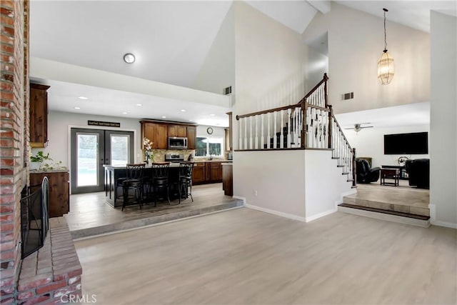 17321 Sunset View Dr, Riverside, CA 92504 - living room featuring light wood-style floors, stairs, high vaulted ceiling, recessed lighting, and a brick fireplace