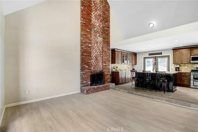 17321 Sunset View Dr, Riverside, CA 92504 - living area with light wood-type flooring, a fireplace, high vaulted ceiling, recessed lighting, and a dry bar
