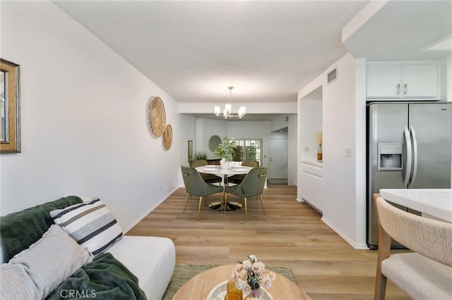 7038 De Celis Pl Unit 4, Van Nuys, CA 91406 - dining space featuring a chandelier, light wood-style floors, and a textured ceiling