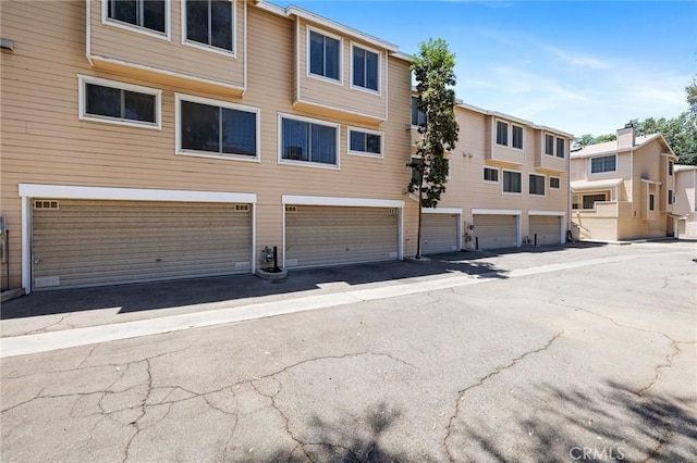 7038 De Celis Pl Unit 4, Van Nuys, CA 91406 - view of building exterior featuring an attached garage and a residential view